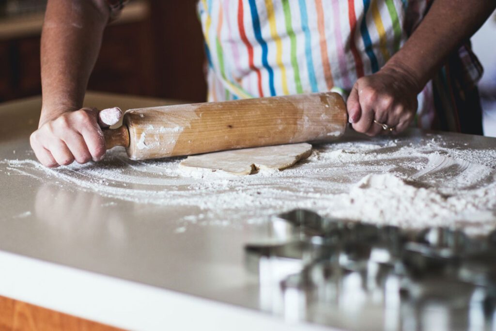 a person rolling out holiday cookies